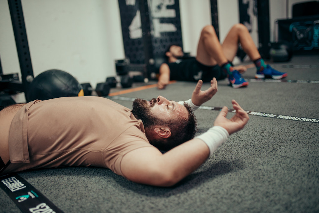 Two athletes take a break after a challenging workout in a gym