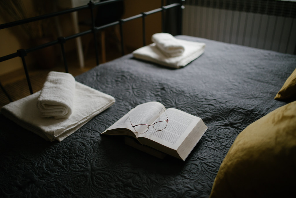 Cozy bedroom with a book and glasses on the bed in a warm atmosphere
